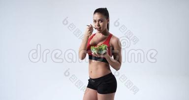<strong>运动健身</strong>年轻女孩吃蔬菜沙拉和微笑，健康的生活方式概念，白色背景。 4k